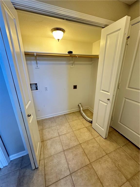 109 Deerfield Dr, Warrensburg, MO 64093 - laundry area with laundry area, light tile patterned flooring, baseboards, and hookup for a washing machine