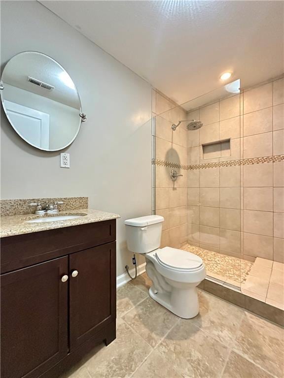 109 Deerfield Dr, Warrensburg, MO 64093 - bathroom featuring toilet, tiled shower, vanity, and visible vents