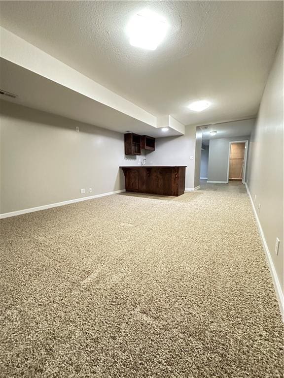 109 Deerfield Dr, Warrensburg, MO 64093 - finished below grade area with light carpet, a textured ceiling, visible vents, and bar