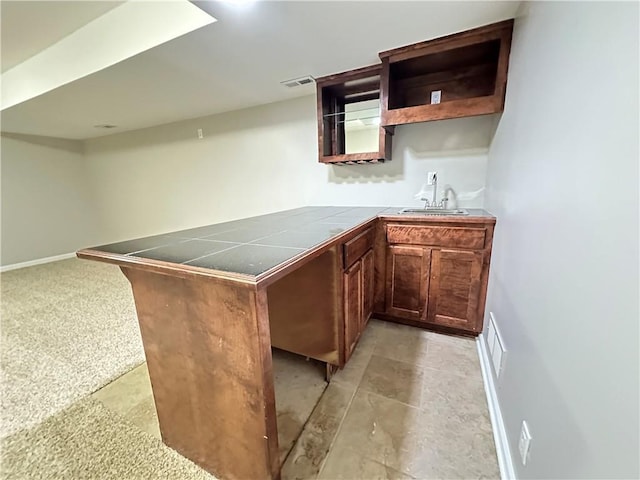 109 Deerfield Dr, Warrensburg, MO 64093 - kitchen featuring visible vents, open shelves, a sink, a peninsula, and tile counters