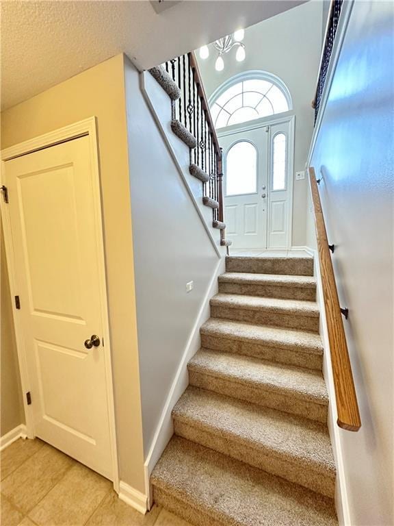 109 Deerfield Dr, Warrensburg, MO 64093 - stairs with tile patterned floors, baseboards, and a textured ceiling
