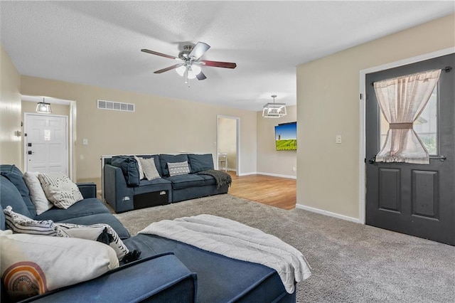 carpeted living room with ceiling fan and baseboards