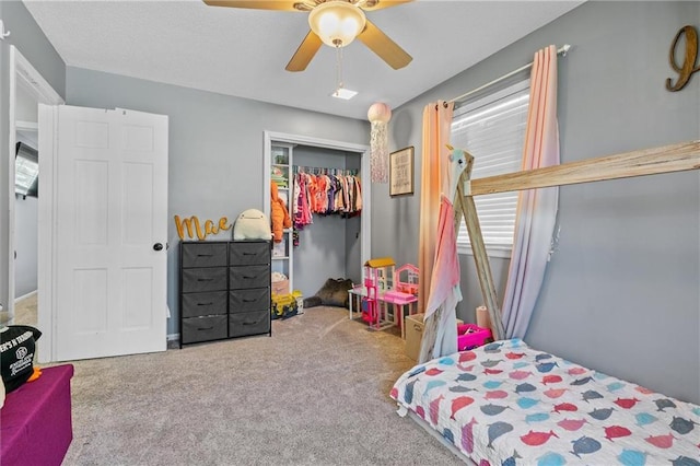carpeted bedroom with ceiling fan and a closet