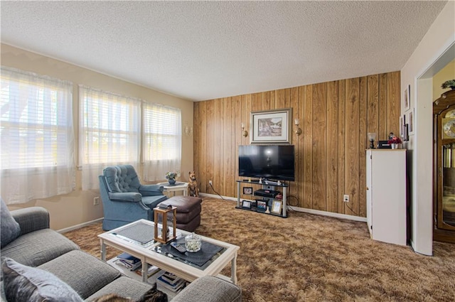 living room with wooden walls, carpet, a textured ceiling, and baseboards