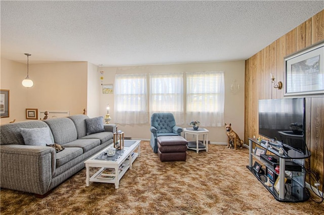 living room with healthy amount of natural light, a textured ceiling, carpet flooring, and wood walls