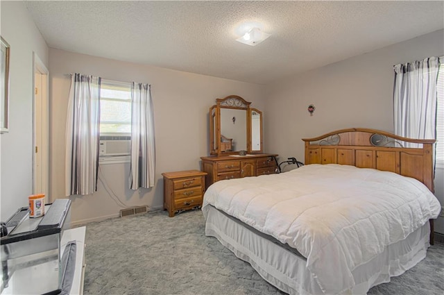 bedroom featuring light colored carpet and a textured ceiling