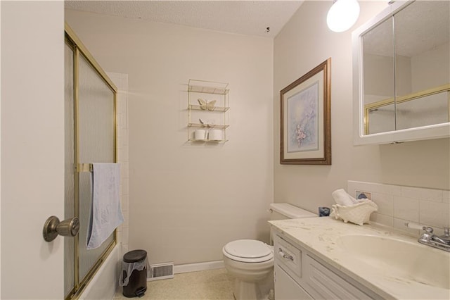 bathroom with toilet, vanity, and enclosed tub / shower combo