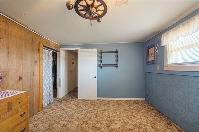 carpeted spare room with wood walls