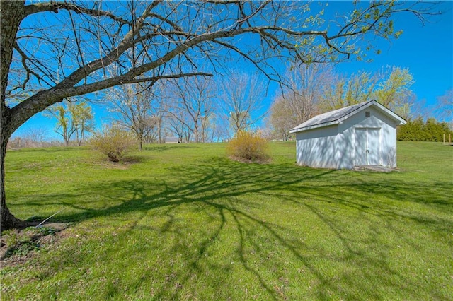 view of green lawn featuring a shed and an outbuilding