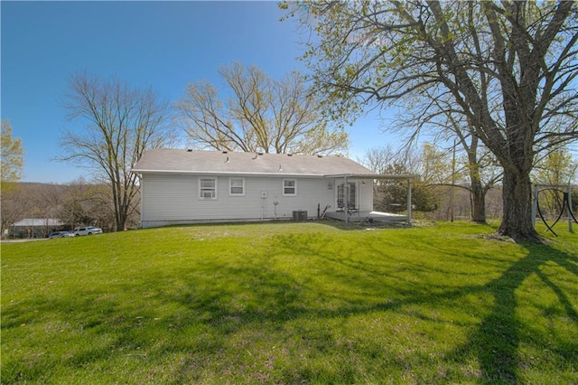 back of house featuring a lawn, cooling unit, and a patio