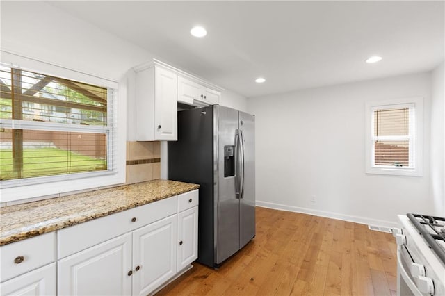 805 N 18th St, Kansas City, KS 66102 - kitchen featuring stainless steel fridge with ice dispenser, range with gas cooktop, white cabinets, light wood finished floors, and recessed lighting