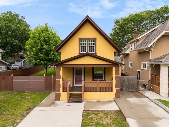 805 N 18th St, Kansas City, KS 66102 - view of front of home with covered porch, stucco siding, a gate, and fence