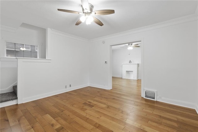 805 N 18th St, Kansas City, KS 66102 - spare room featuring ceiling fan, stairs, wood-type flooring, ornamental molding, and a fireplace