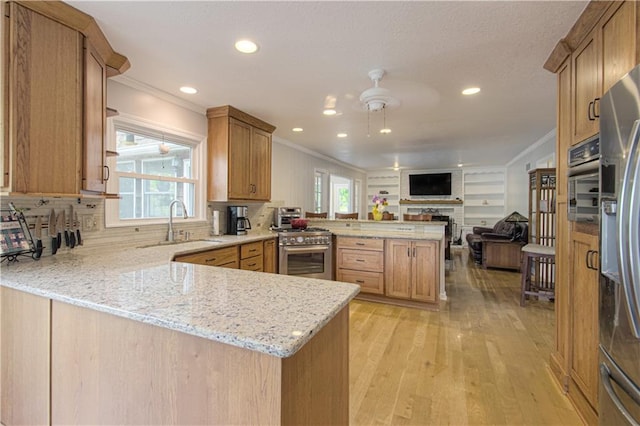 13605 W 48th St, Shawnee, KS 66216 - kitchen with a peninsula, crown molding, open floor plan, a sink, and light wood-style floors
