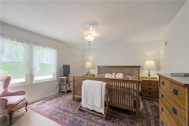 13605 W 48th St, Shawnee, KS 66216 - bedroom featuring wood finished floors, baseboards, ornamental molding, and a textured ceiling
