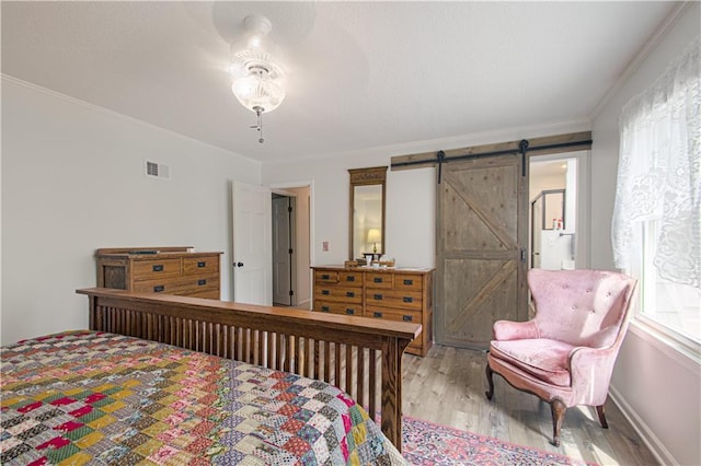 13605 W 48th St, Shawnee, KS 66216 - bedroom with a barn door, wood finished floors, crown molding, and baseboards