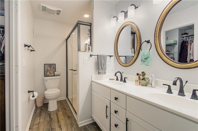 13605 W 48th St, Shawnee, KS 66216 - bathroom with wood finished floors, a spacious closet, a shower stall, toilet, and double vanity