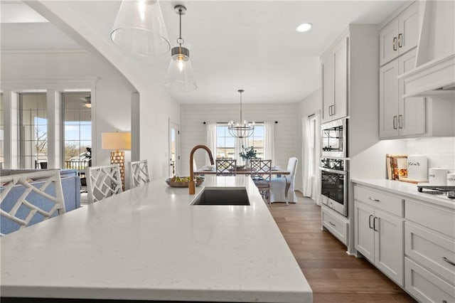 8016 Round Prairie St, Shawnee, KS 66220 - kitchen with recessed lighting, a sink, custom range hood, dark wood-type flooring, and pendant lighting