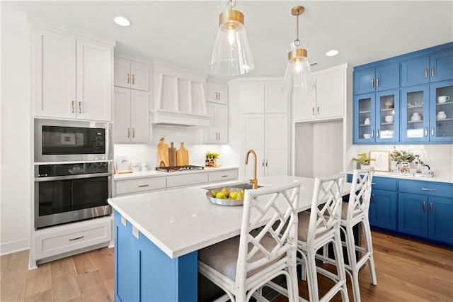 8016 Round Prairie St, Shawnee, KS 66220 - kitchen with appliances with stainless steel finishes, blue cabinetry, light countertops, and backsplash