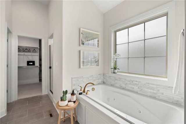 8016 Round Prairie St, Shawnee, KS 66220 - bathroom with a walk in closet, baseboards, a shower stall, and a jetted tub