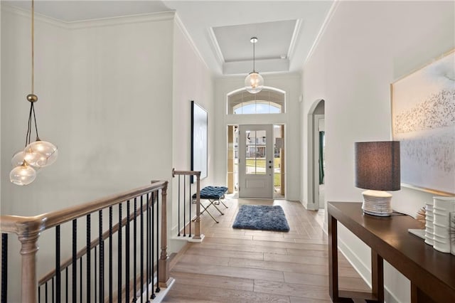 8016 Round Prairie St, Shawnee, KS 66220 - entrance foyer featuring arched walkways, light wood-style flooring, a chandelier, ornamental molding, and a raised ceiling