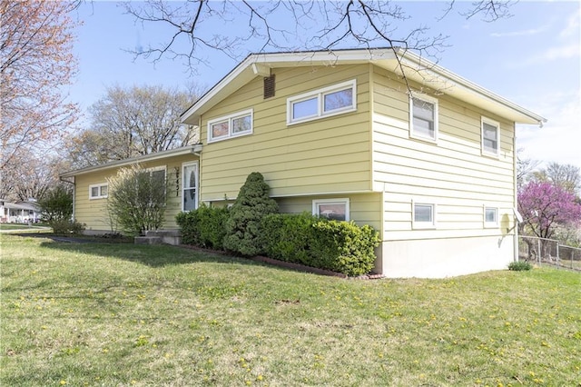 view of property exterior featuring a yard and fence