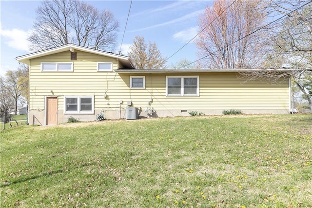 back of house featuring central air condition unit and a lawn
