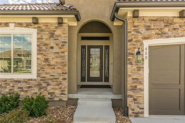 420 NW Kaylea Ct, Lees Summit, MO 64081 - doorway to property featuring stone siding, stucco siding, and a tile roof