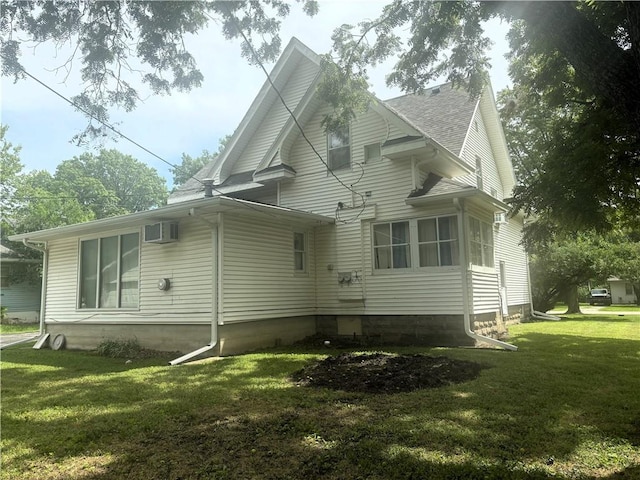 214 W 5th St, Lebo, KS 66856 - view of side of home featuring a yard, a shingled roof, and a wall unit AC