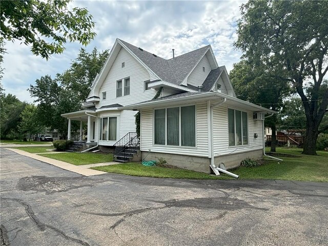 214 W 5th St, Lebo, KS 66856 - view of front of home featuring roof with shingles and a front lawn