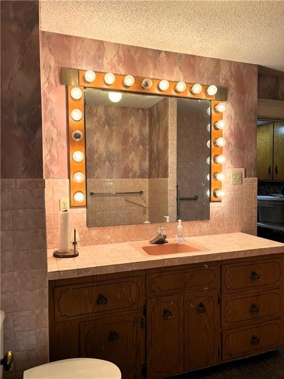 214 W 5th St, Lebo, KS 66856 - bathroom with a textured ceiling, decorative backsplash, tile walls, and vanity