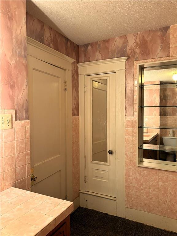 214 W 5th St, Lebo, KS 66856 - hall featuring a textured ceiling and tile walls