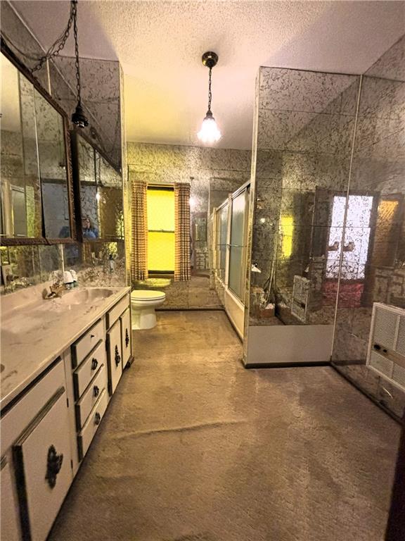 214 W 5th St, Lebo, KS 66856 - full bathroom featuring a stall shower, vanity, and a textured ceiling