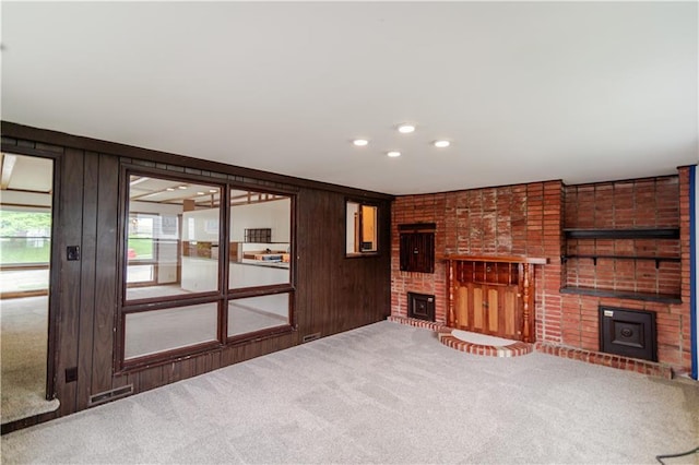 717 Y St, Atchison, KS 66002 - unfurnished living room with a fireplace, carpet flooring, wood walls, french doors, and recessed lighting