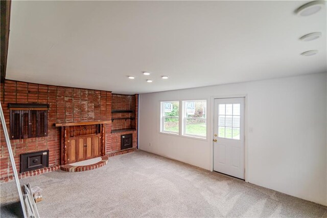 717 Y St, Atchison, KS 66002 - unfurnished living room with a fireplace, carpet floors, brick wall, and recessed lighting