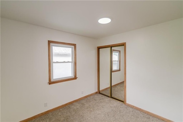 717 Y St, Atchison, KS 66002 - unfurnished bedroom featuring light carpet, a closet, and baseboards