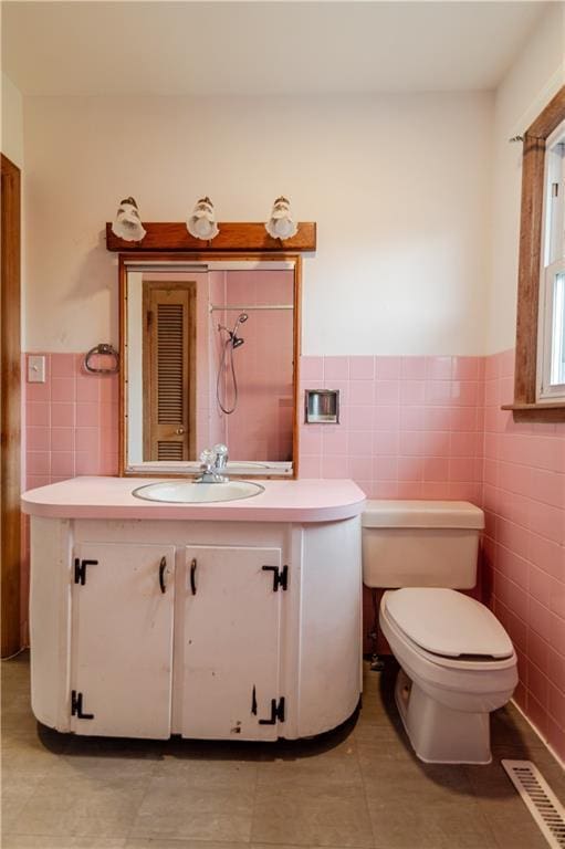 717 Y St, Atchison, KS 66002 - bathroom with tile walls, vanity, a wainscoted wall, toilet, and tile patterned flooring
