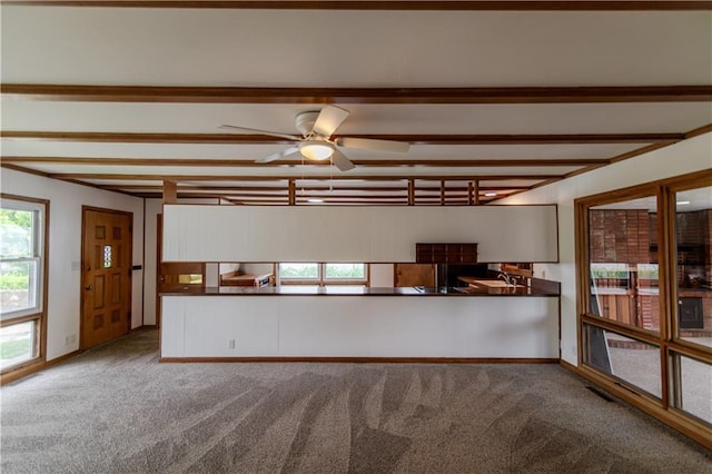717 Y St, Atchison, KS 66002 - kitchen with carpet, dark countertops, beam ceiling, a ceiling fan, and a sink