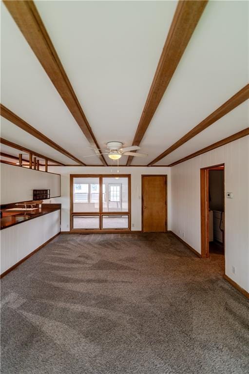717 Y St, Atchison, KS 66002 - unfurnished living room with carpet flooring, beam ceiling, ceiling fan, and baseboards
