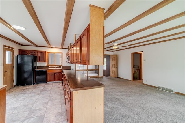 717 Y St, Atchison, KS 66002 - kitchen with black appliances, beamed ceiling, a sink, brown cabinetry, and dark countertops