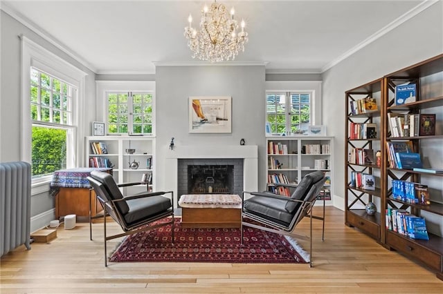 4525 Kenwood Ave, Kansas City, MO 64110 - sitting room with radiator heating unit, a brick fireplace, wood finished floors, and baseboards