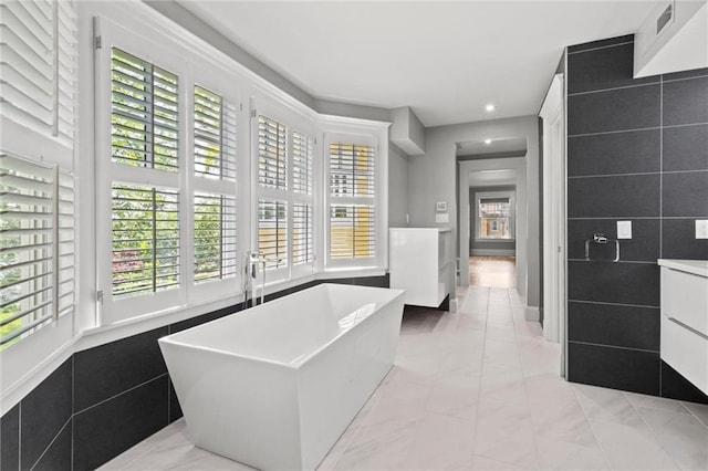 4525 Kenwood Ave, Kansas City, MO 64110 - interior space with recessed lighting, vanity, marble finish floor, and a soaking tub