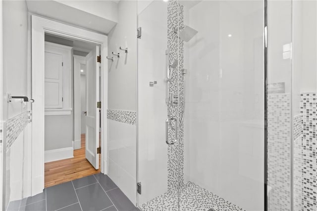 4525 Kenwood Ave, Kansas City, MO 64110 - bathroom with a shower stall, tile patterned floors, and tile walls