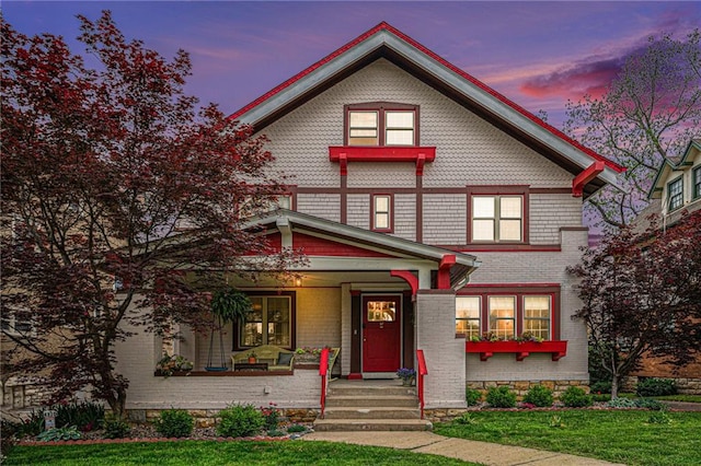 4310 Warwick Blvd, Kansas City, MO 64111 - victorian home with covered porch, a front lawn, and brick siding
