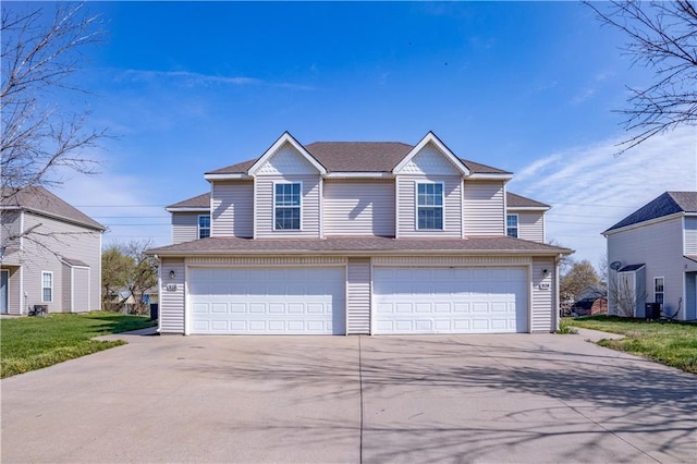 traditional-style house with roof with shingles, driveway, cooling unit, and an attached garage