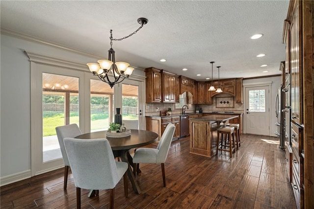 9015 Craig Dr, De Soto, KS 66018 - dining room with a chandelier, dark wood finished floors, a textured ceiling, crown molding, and recessed lighting
