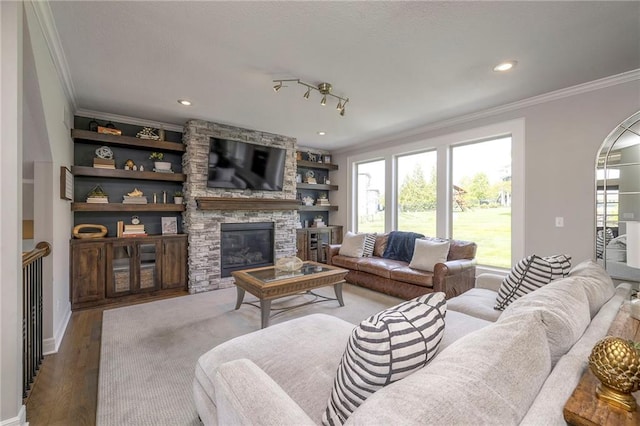 living room featuring wood finished floors, recessed lighting, a fireplace, crown molding, and baseboards