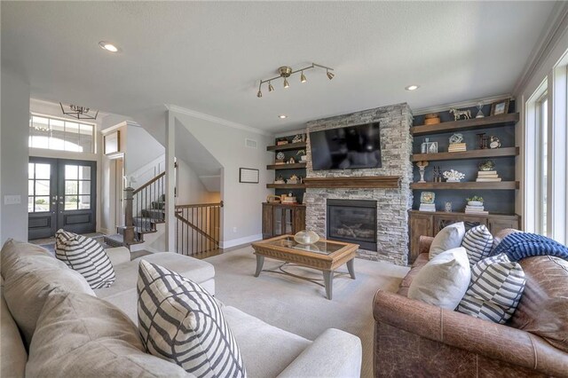 living area with light colored carpet, crown molding, plenty of natural light, and stairway
