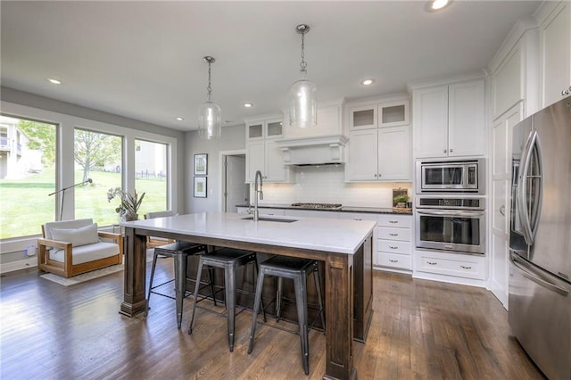 kitchen with a sink, stainless steel appliances, white cabinetry, and recessed lighting