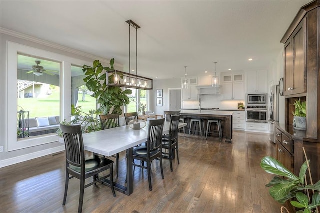 dining area featuring dark wood-type flooring, baseboards, ornamental molding, and recessed lighting